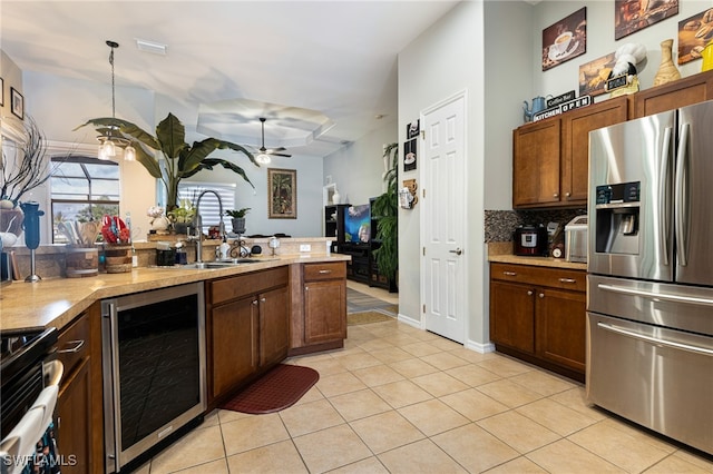 kitchen featuring wine cooler, sink, light tile patterned floors, appliances with stainless steel finishes, and backsplash