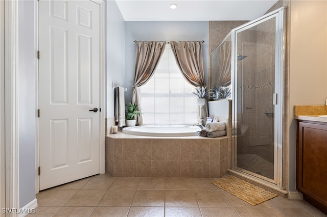 bathroom featuring vanity, shower with separate bathtub, and tile patterned flooring