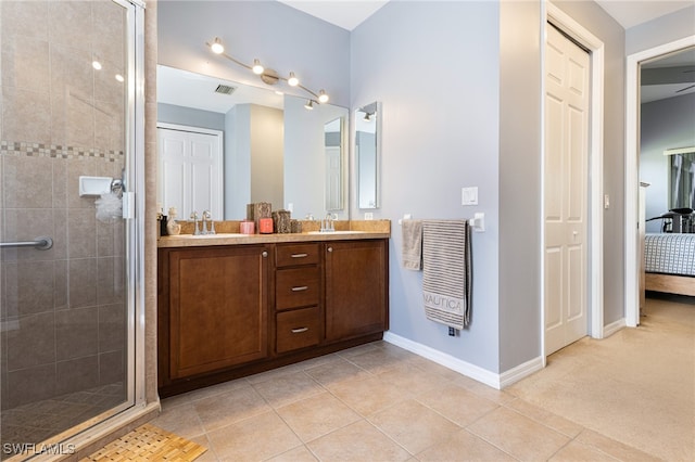 bathroom with vanity, a shower with shower door, and tile patterned flooring