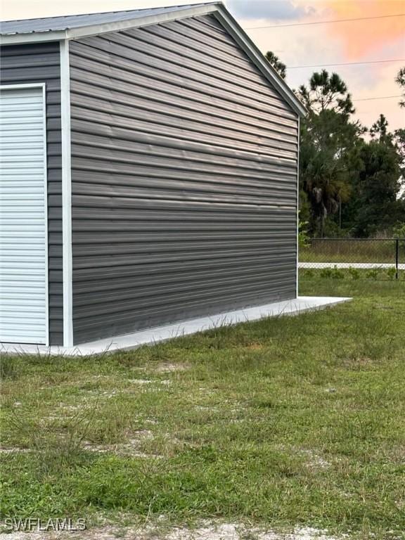 property exterior at dusk featuring a yard