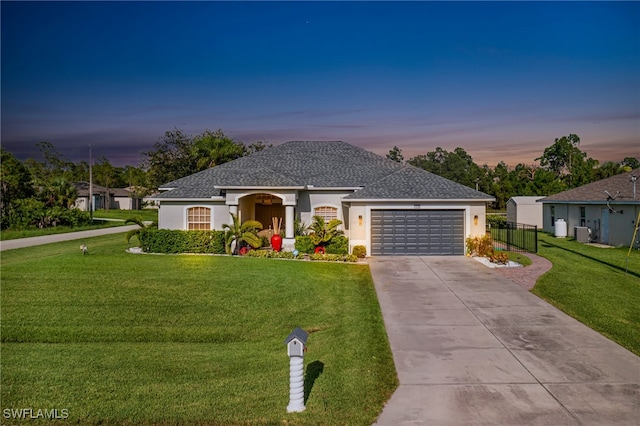 view of front of house with a garage and a lawn