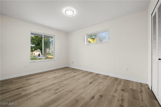 1628 SW 11th Ave, Cape Coral, FL 33991 - unfurnished bedroom featuring wood finished floors, multiple windows, and baseboards