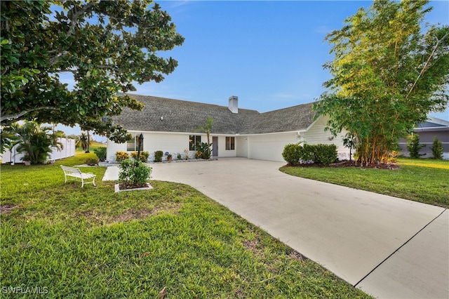 ranch-style home with a garage and a front lawn
