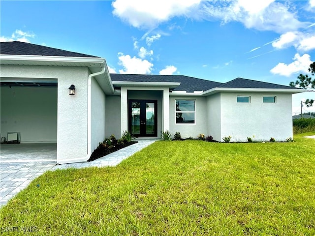 doorway to property with a lawn, french doors, and a garage