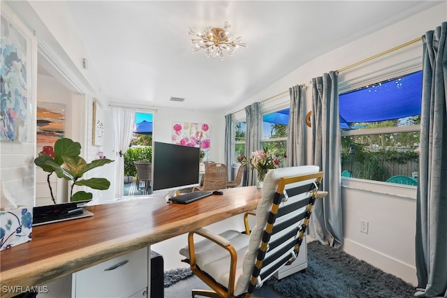 office with plenty of natural light, carpet floors, a chandelier, and lofted ceiling