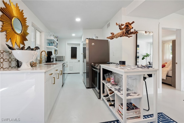 kitchen with stainless steel appliances, white cabinetry, plenty of natural light, and sink