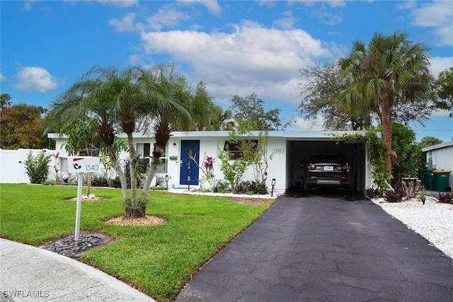 single story home featuring driveway, a carport, and a front yard