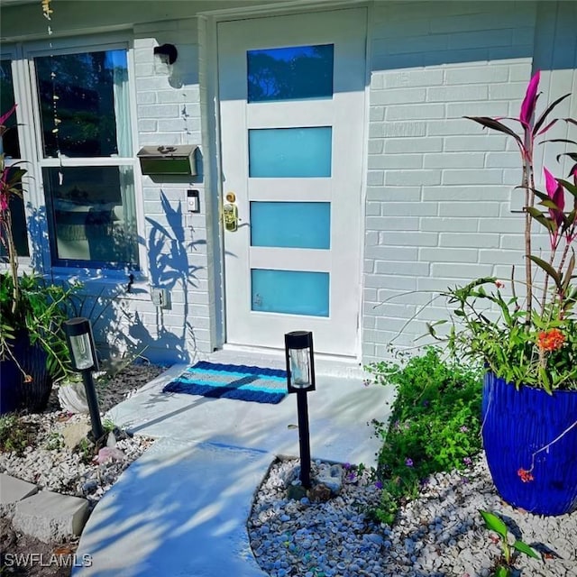 doorway to property featuring brick siding