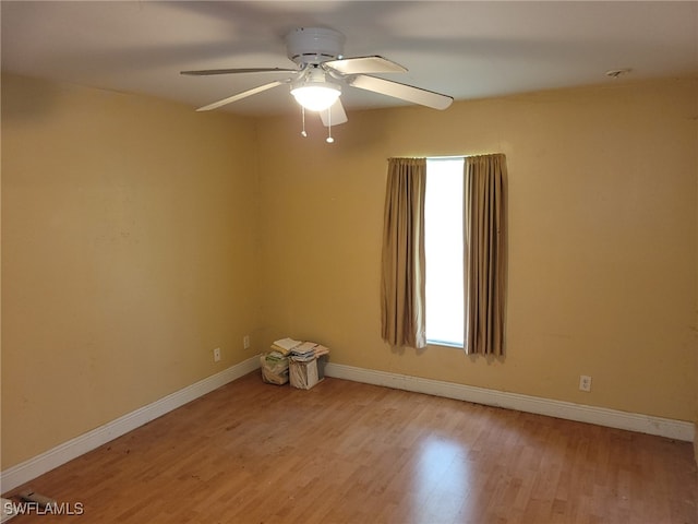 empty room with ceiling fan and light hardwood / wood-style floors