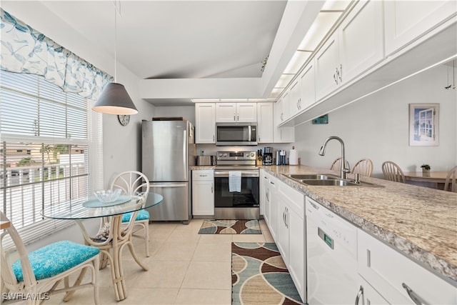 kitchen featuring light tile patterned floors, white cabinets, hanging light fixtures, appliances with stainless steel finishes, and sink