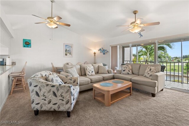 carpeted living room featuring vaulted ceiling and ceiling fan