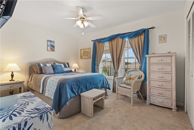 bedroom with light carpet, ceiling fan, and a closet