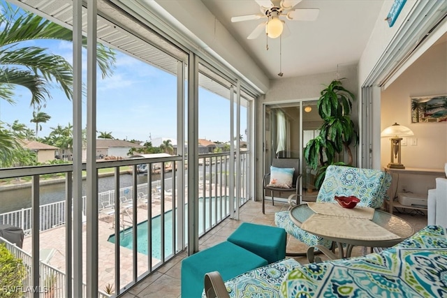 sunroom / solarium featuring a water view and ceiling fan