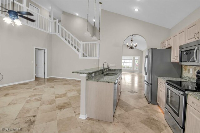 kitchen with appliances with stainless steel finishes, backsplash, sink, high vaulted ceiling, and hanging light fixtures