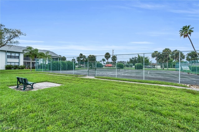 view of home's community featuring a yard and tennis court