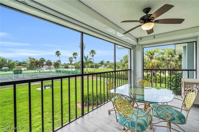 unfurnished sunroom with ceiling fan