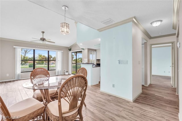 dining room featuring ornamental molding, vaulted ceiling, light hardwood / wood-style floors, and ceiling fan with notable chandelier