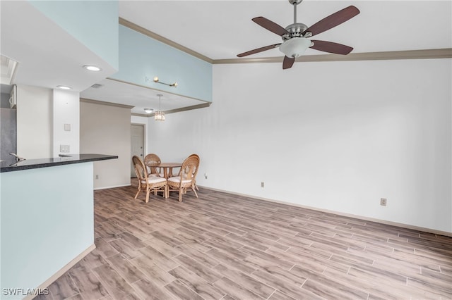 dining area featuring light wood-type flooring, crown molding, and ceiling fan