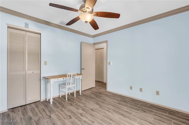 unfurnished bedroom with ceiling fan, ornamental molding, and a closet