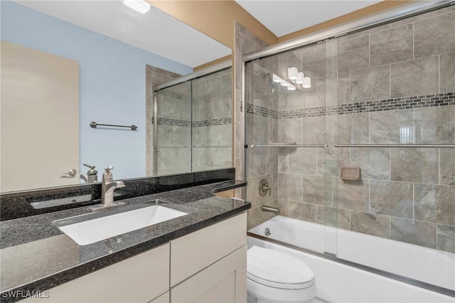 full bathroom with shower / bath combination with glass door, vanity, and toilet