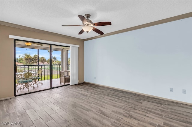 empty room featuring ceiling fan, light wood-type flooring, a textured ceiling, and crown molding