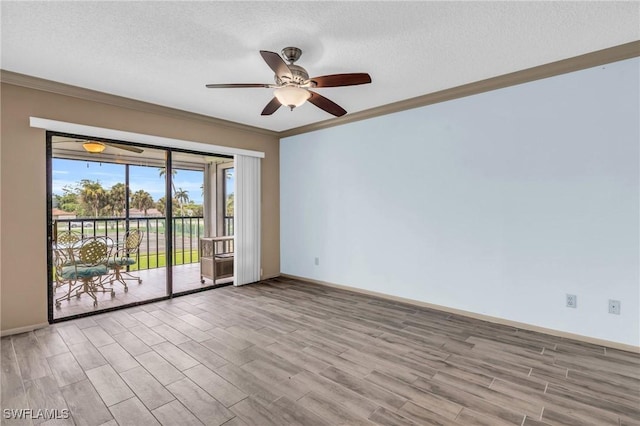 empty room featuring ceiling fan, light wood-type flooring, crown molding, and a textured ceiling