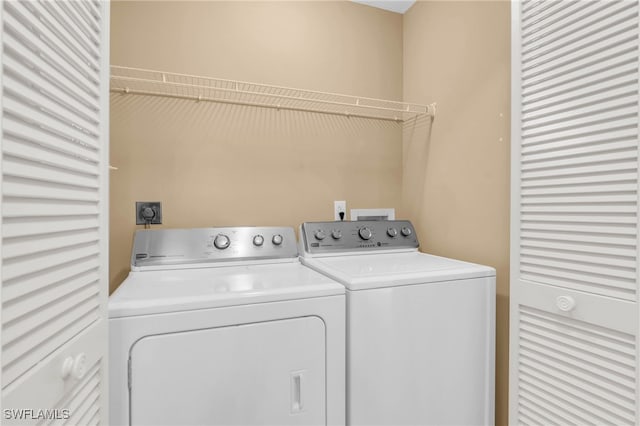 clothes washing area featuring separate washer and dryer