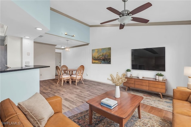 living room with ceiling fan, light hardwood / wood-style flooring, and ornamental molding