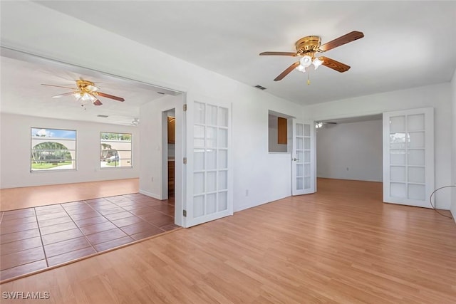 unfurnished room with visible vents, french doors, wood finished floors, and a ceiling fan