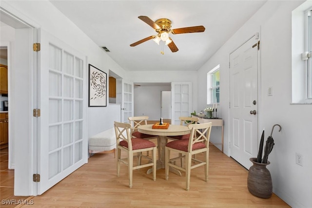 dining area featuring a ceiling fan, light wood-type flooring, and visible vents