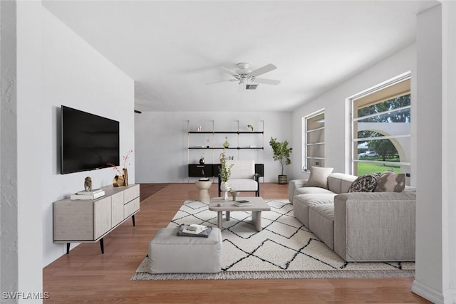 living room featuring wood-type flooring and ceiling fan