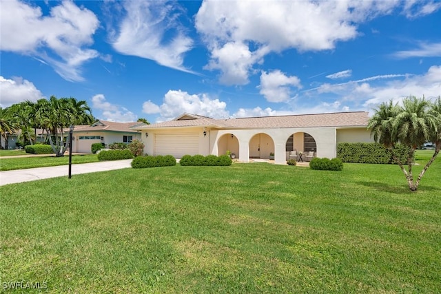 view of front facade with a garage, a front yard, driveway, and stucco siding