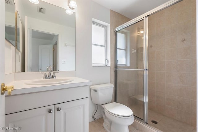 bathroom with toilet, a stall shower, vanity, and tile patterned floors