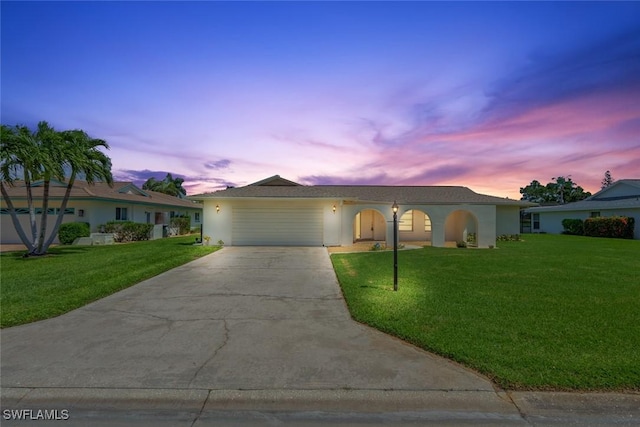 single story home with a garage and a lawn