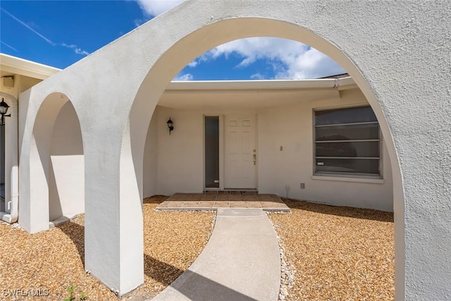 view of exterior entry featuring stucco siding