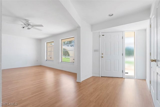 entryway with light wood finished floors, baseboards, and a ceiling fan