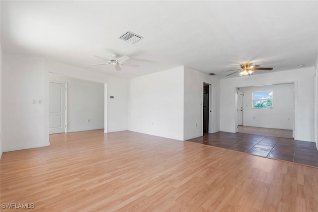 empty room featuring ceiling fan, wood finished floors, and visible vents