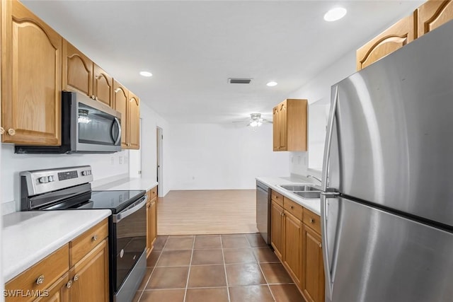 kitchen with dark tile patterned flooring, a sink, visible vents, light countertops, and appliances with stainless steel finishes