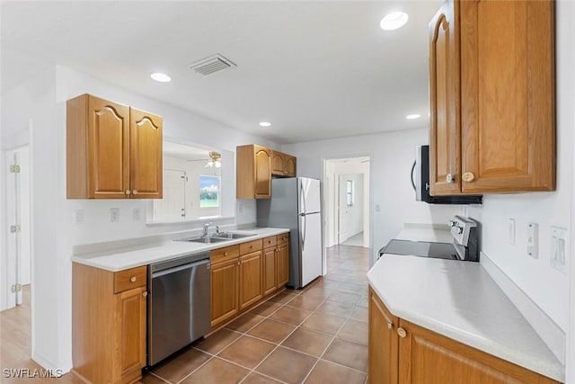 kitchen with light countertops, electric range oven, freestanding refrigerator, a sink, and dishwasher