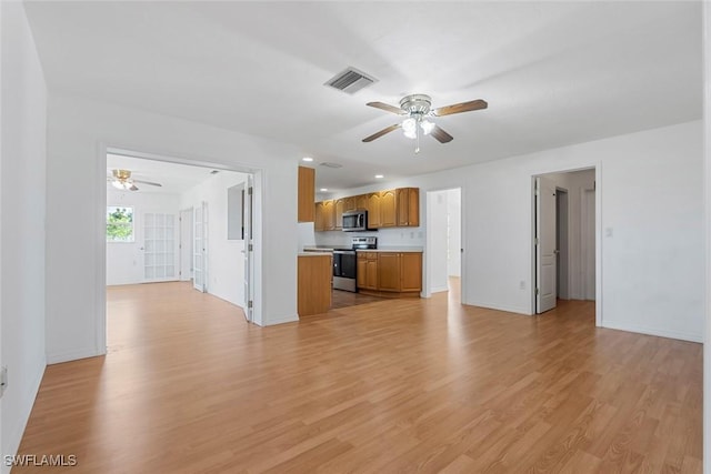 kitchen featuring stainless steel appliances, light countertops, visible vents, brown cabinetry, and open floor plan