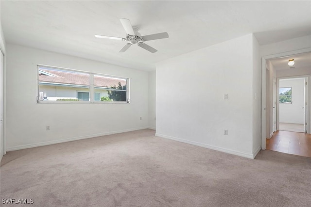 unfurnished room featuring ceiling fan, carpet floors, plenty of natural light, and baseboards