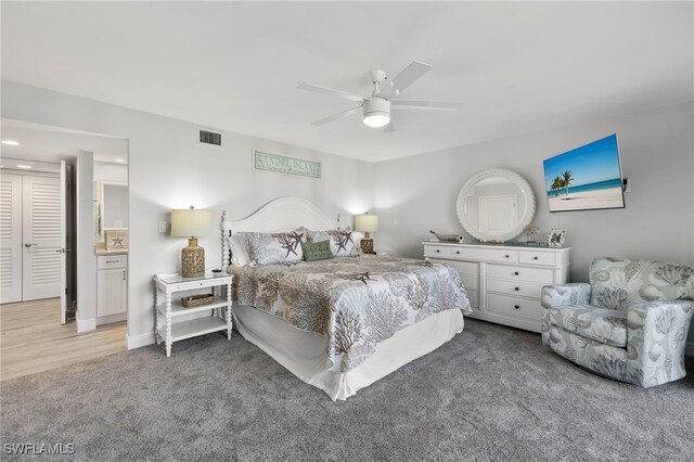 bedroom featuring ceiling fan, light hardwood / wood-style flooring, and ensuite bath