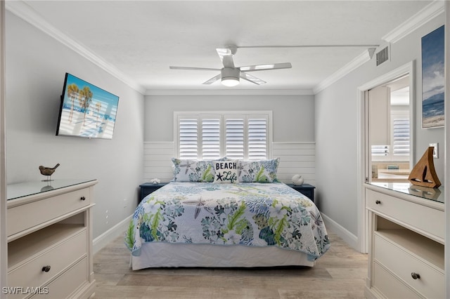 bedroom with light hardwood / wood-style flooring, ornamental molding, and ceiling fan