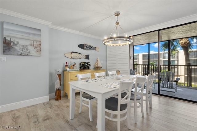 dining room with light hardwood / wood-style flooring, crown molding, and a chandelier