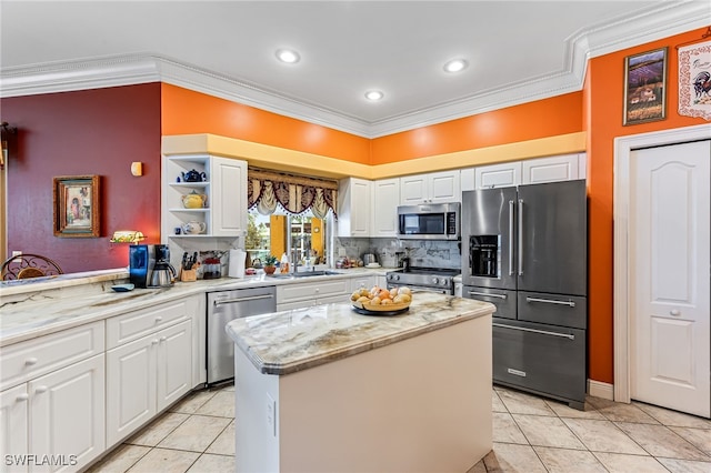 kitchen featuring a kitchen island, ornamental molding, white cabinetry, light tile patterned floors, and appliances with stainless steel finishes