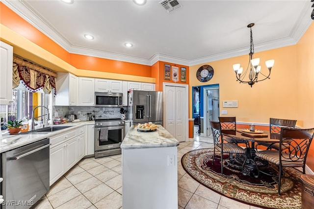 kitchen featuring hanging light fixtures, stainless steel appliances, a center island, light tile patterned floors, and white cabinetry