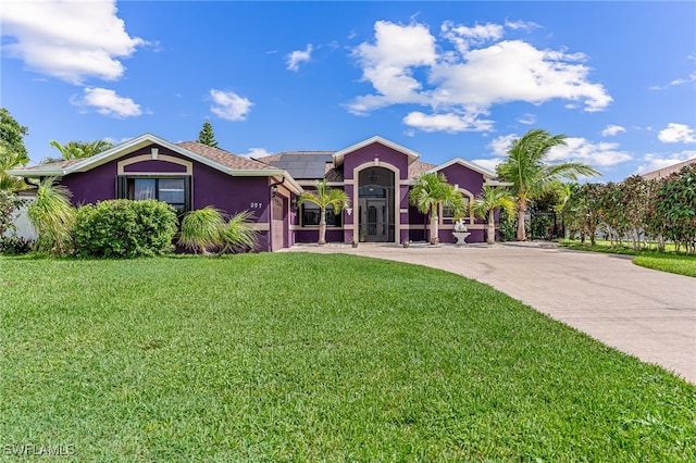 view of front of property featuring a front lawn and solar panels