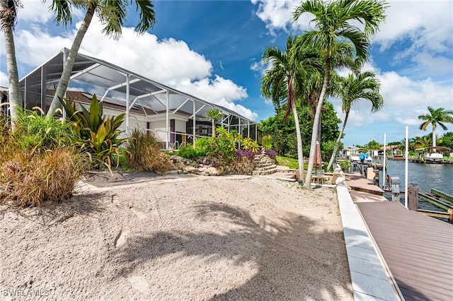 exterior space with a dock, a water view, and a lanai