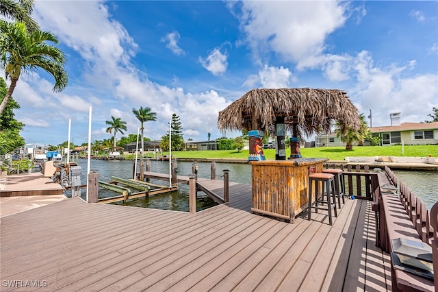 dock area featuring a water view and a lawn