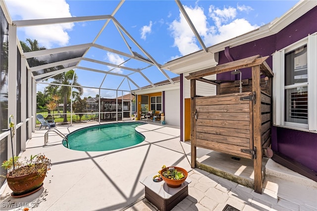 view of pool with a patio and glass enclosure